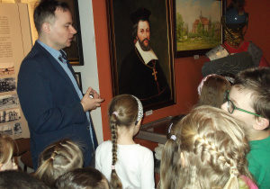 Dzieci oglądają zdjęcia, obrazy, eksponaty związane z historią mieszkańców Łasku.